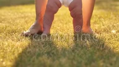 小孩子学会走路。 宝贝在草地上的第一步。